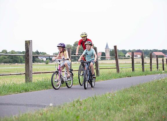 Opa mit Kindern auf Radtour Opa mit zwei Kindern auf Fahrradweg im ländlicher Umgebung